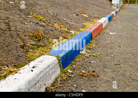 Rosso, bianco e blu dipinto di cordoli di marciapiede in una strada di Belfast Foto Stock