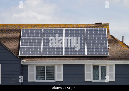 Dodici pannelli solari fotovoltaici su un efficiente dal punto di vista energetico eco casa residenziale sul tetto di proprietà nazionale. West Sussex, in Inghilterra, Regno Unito, Gran Bretagna Foto Stock