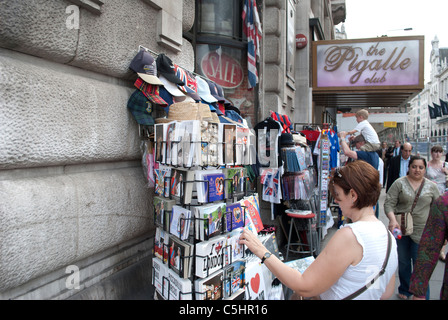 Donna che guarda le Cartoline turistiche al di fuori del negozio di souvenir vicino a Piccadilly Circus Londra Foto Stock