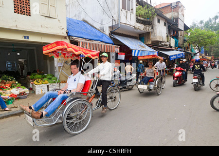 I turisti prendere il cyclo tour nel distretto storico di Hanoi, Vietnam. Queste biciclette risciò guidati sono popolari con i turisti. Foto Stock