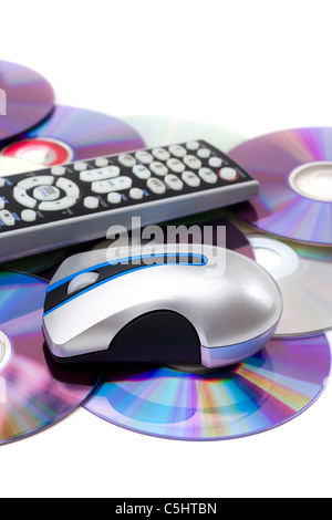 TV con telecomando e mouse del computer su una pila di sparse dischi dvd isolato su bianco. Foto Stock