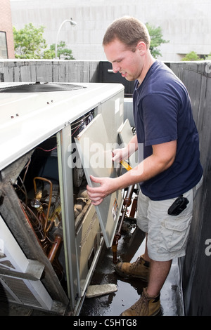 Un impianto di termoventilazione di riscaldamento, ventilazione e aria condizionata tecnico che lavora su una grande unità commerciale. Foto Stock