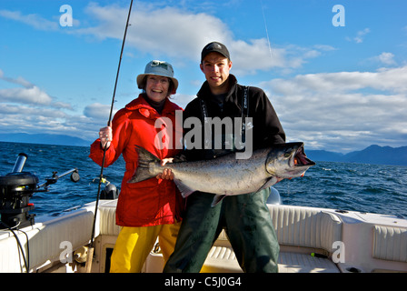 Pescatore femmina sport guida di pesca tenendo grande Salmone Chinook aperto oceano pacifico suono Kyuquot BC Foto Stock