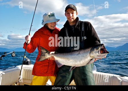 Pescatore femmina sport guida di pesca tenendo grande Salmone Chinook aperto oceano pacifico suono Kyuquot BC Foto Stock