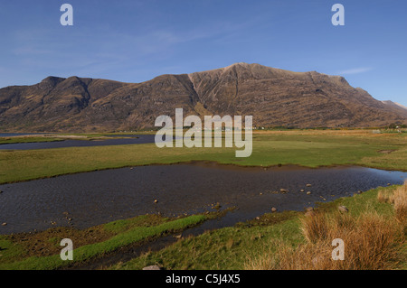 Una vista attraverso le piane di marea verso la montagna, Liathach e sparsi di casette bianche di Torridon borgo sottostante, Torridon, Foto Stock