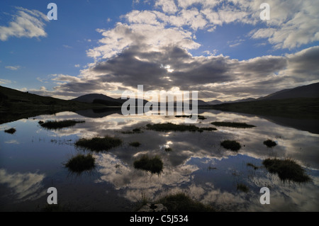 Nuvole retroilluminato e profondo cielo blu sopra Loch Tulla, Rannoch Moor, Highlands scozzesi, UK. Foto Stock