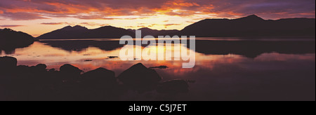 Drammatico tramonto riflesso in acque calme, con gamma di colline (Ardgour) lungo orizzonte, inil giunzione del Loch Linnhe e Loch Foto Stock
