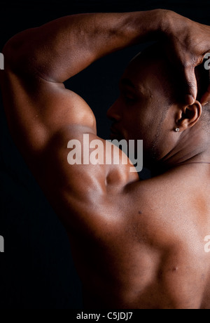 Muscoloso americano africano uomo mostrare la sua schiena e i muscoli della spalla Foto Stock