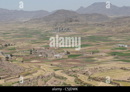 Pendio terrazzato in Yemen con un villaggio della valle Foto Stock