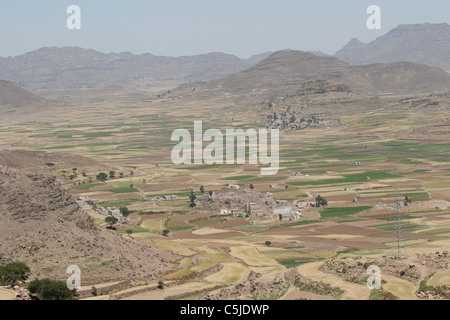 Pendio terrazzato in Yemen con un villaggio della valle Foto Stock