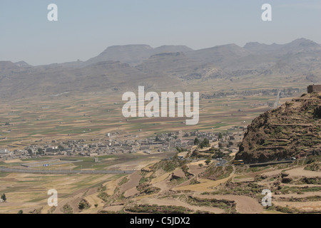 Pendio terrazzato in Yemen con un villaggio della valle Foto Stock