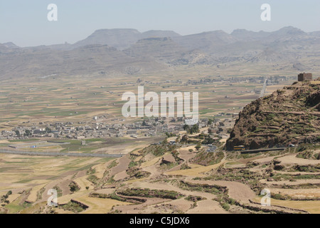 Pendio terrazzato in Yemen con un villaggio della valle Foto Stock