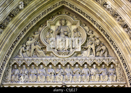Dettaglio di sculture in pietra di Gesù, angeli e discepoli sul timpano della grande porta Nord, l'Abbazia di Westminster, Londra, Inghilterra Foto Stock
