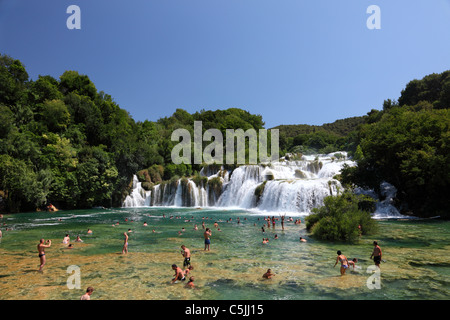 I bagnanti di fronte alla cascata nel Parco Nazionale di Krka, Croazia Foto Stock