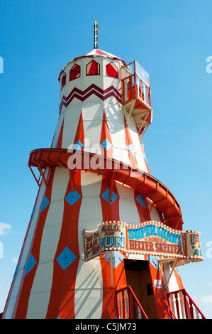 Helter Skelter fairground ride di fronte luminoso cielo blu Foto Stock