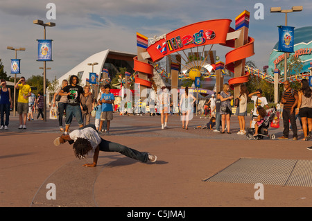 Un esecutore di strada musicista di strada al di fuori dell'entrata al Villaggio Disney a Disneyland Paris in Francia Foto Stock