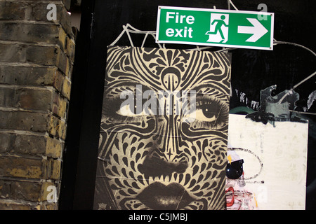 Graffiti su un incendio alla porta di uscita in Shoreditch, Londra Foto Stock