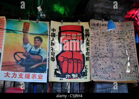 La rivoluzione culturale era (1960 a 70's) manifesti di propaganda sono in vendita in uno stand. Pechino, Cina. Foto Stock