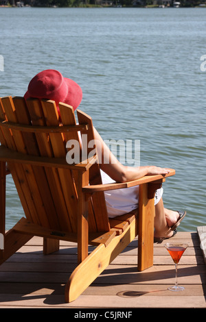 Una signora appoggiato accanto a un lago Foto Stock