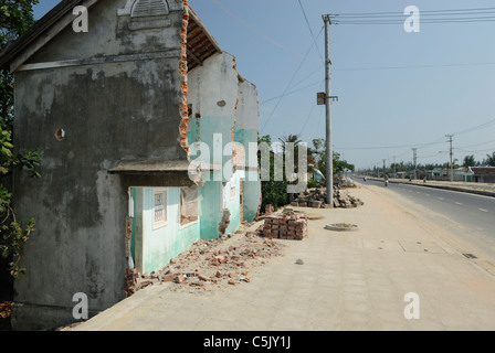 Asia, Vietnam, nr. Hoi An. Lungo la strada costiera tra Hoi An e Da Nang, case sono state tagliate a metà per fare spazio al nuovo Foto Stock