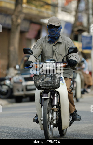 Asia Vietnam Hanoi. Hanoi old quarter. Uomini vietnamita in sella a una moto (ciclomotore) attraverso Hanoi. Foto Stock