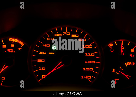 Un primo piano di un moderno per interni auto cruscotto. Questo è il driver cockpit con le linee e i numeri incandescente in rosso. Foto Stock