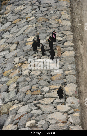 Vista aerea di otto donne in burqas sulle rocce dal mare, Buyukcekmece, Istanbul, Turchia Foto Stock