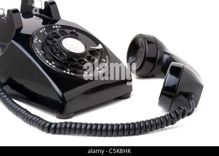 Un vecchio nero vintage stile rotativo telefono sganciato isolate su uno sfondo bianco. Foto Stock