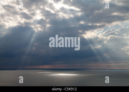 Striature di luce del sole attraverso le nuvole pesanti su Barmouth, Galles. Foto Stock