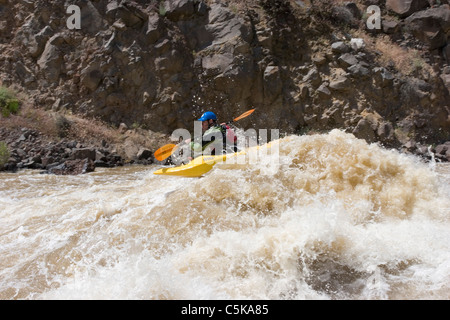 L'uomo pagaie Kayak attraverso Whitewater Foto Stock