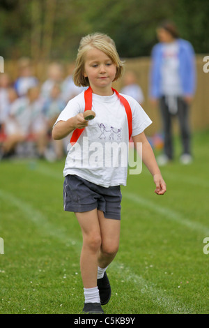 Ragazza giovane competere in uovo e cucchiaio gara su sportsday Foto Stock