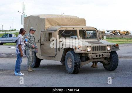 Local uomo parla a Iowa l esercito nazionale soldati di guardia a humvee militari degli Stati Uniti di fronte argini presso il fiume Missouri Foto Stock