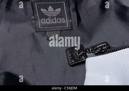 Abbigliamento sportivo Adidas uomini giacca a vento giacca full zip con cappuccio in nylon. Con il logo di trifoglio. Dettaglio di etichetta Foto Stock