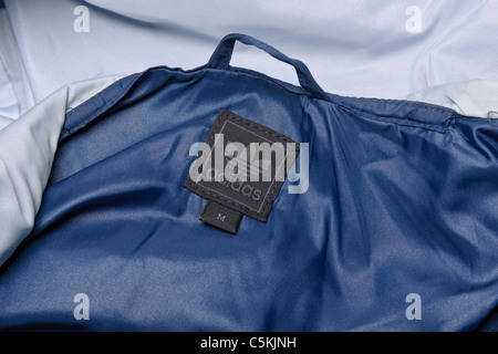 Adidas gamma di Marsiglia sportswear giacca a vento uomo Giacca pioggia in due toni di blu nylon, incappucciati full zip. Dettaglio di etichetta Foto Stock