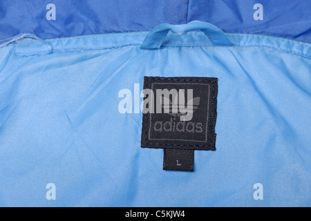 Adidas gamma di Marsiglia sportswear giacca a vento uomo Giacca pioggia in due toni di blu nylon, incappucciati full zip. Dettaglio di etichetta Foto Stock