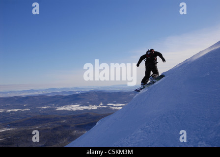 Una pattuglia di sci su di uno snowboard scolpisce il suo modo su un ripido pendio a Mt. Ellen a Sugarbush Resort in Fayston, Vermont. Foto Stock