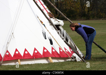 Una persona curiosa cercando all'interno di un nativo americano tende Tepee indiano Foto Stock