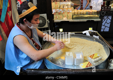 Un giovane uomo che fa candy davanti a un negozio. Chengdu Sichuan, in Cina. Foto Stock