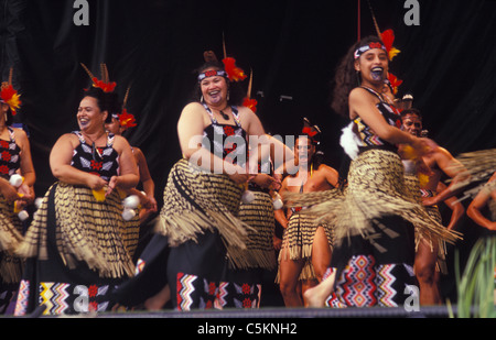Un concerto Maori Party cantando e ballando sul palco, donne presso la parte anteriore con i poi, gli uomini dietro Foto Stock