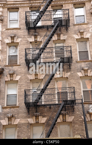 Zig zagging fire escape sulla parte esterna del vecchio edificio di appartamenti a New York City. Foto Stock