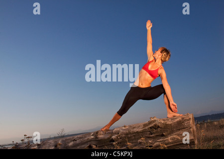 Lo Yoga posa al tramonto, spiaggia a mezzaluna, South Surrey, BC, Canada Foto Stock