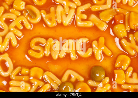 Alfabeto pasta sagomato formante la parola snack in salsa di pomodoro Foto Stock
