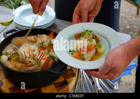 Casseruola di coniglio servita su un tavolo fuori in giardino Foto Stock