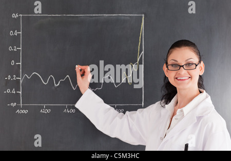 Scienziato sorridente disegno sulla lavagna Foto Stock