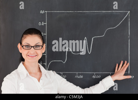 Scienziato che mostra un grafico sulla lavagna Foto Stock