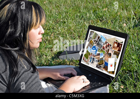 Una giovane donna visualizzazione o modifica di una galleria di foto sul suo computer portatile. Foto Stock