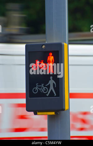 I segnali del traffico, che mostra uomo rosso avvertenze per i pedoni e i ciclisti. Bluured veicolo che mostra il movimento pericoloso in background. Foto Stock