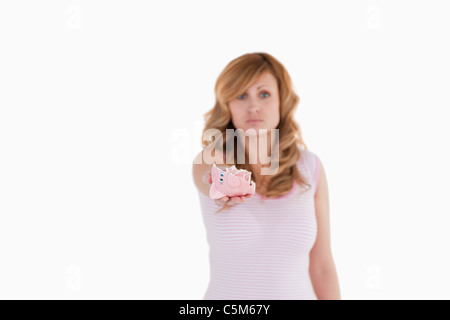 Attraente bionda donna che mostra il suo rotto piggybank Foto Stock