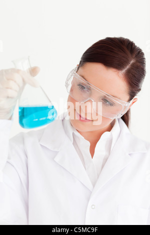 Attraente scienziato tenendo un becher in un laboratorio Foto Stock