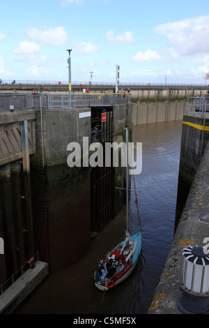 Barca a vela lasciando vuote di blocco e uscire in mare, la Baia di Cardiff Barrage , South Glamorgan, Wales, Regno Unito Foto Stock